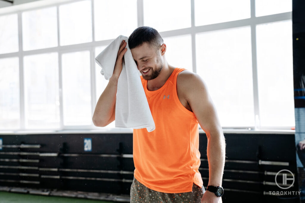 Athletes Rubs with Gym Towel in Gym