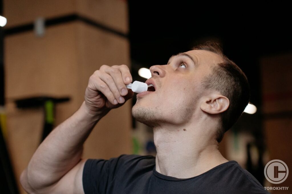 athlete taking creatine in gym