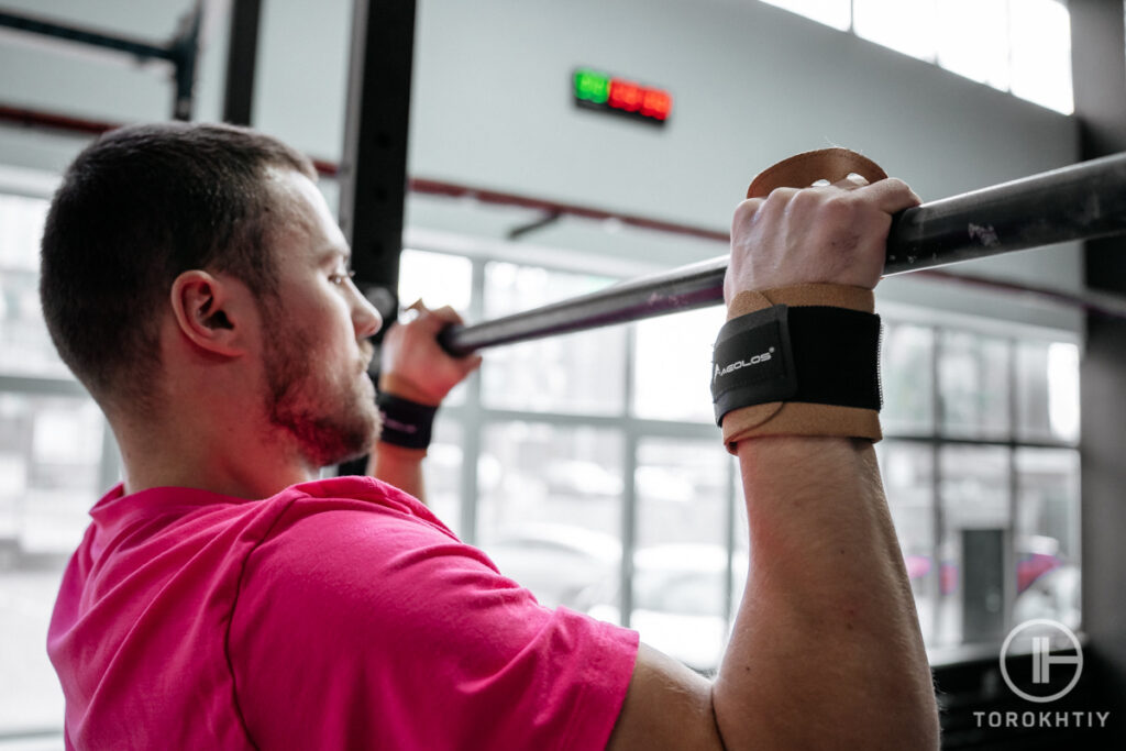 athlete doing pull ups in gym