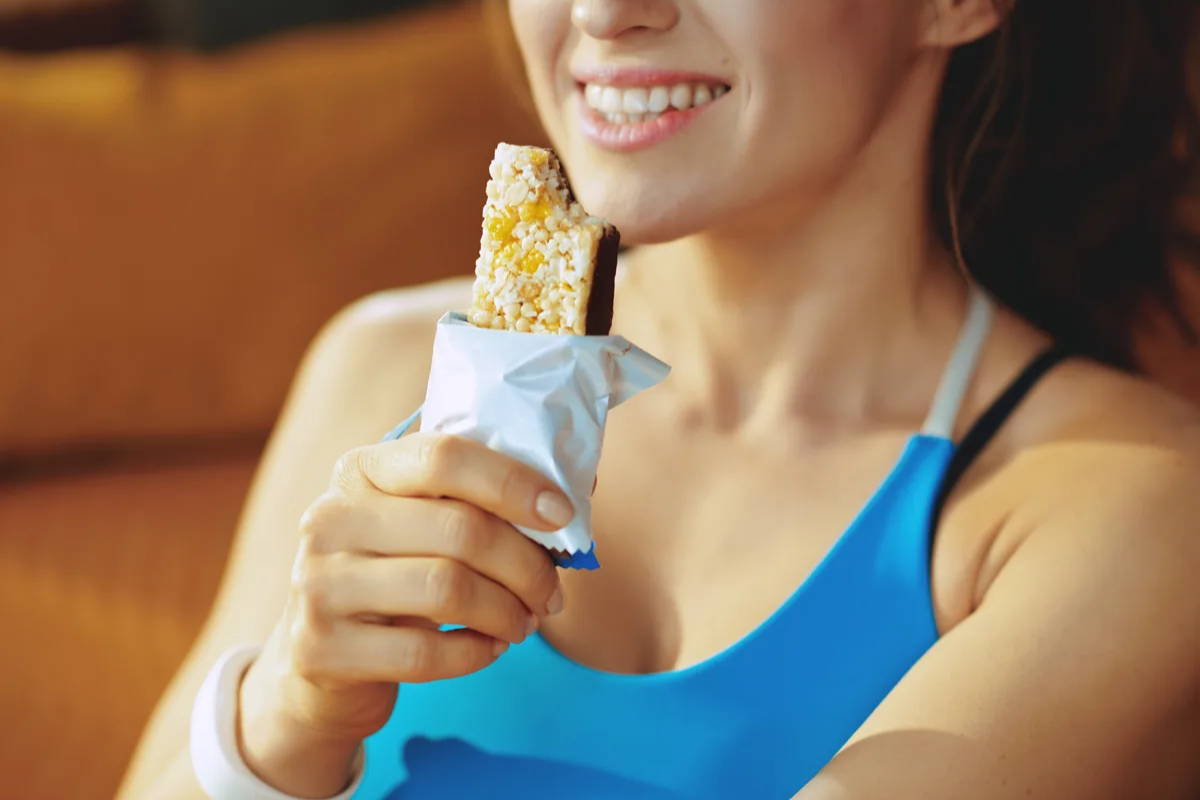 Athlete eating protein bar at gym