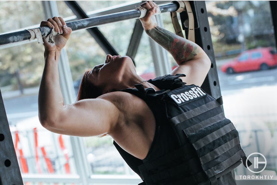 woman doing pull ups with weighted vest