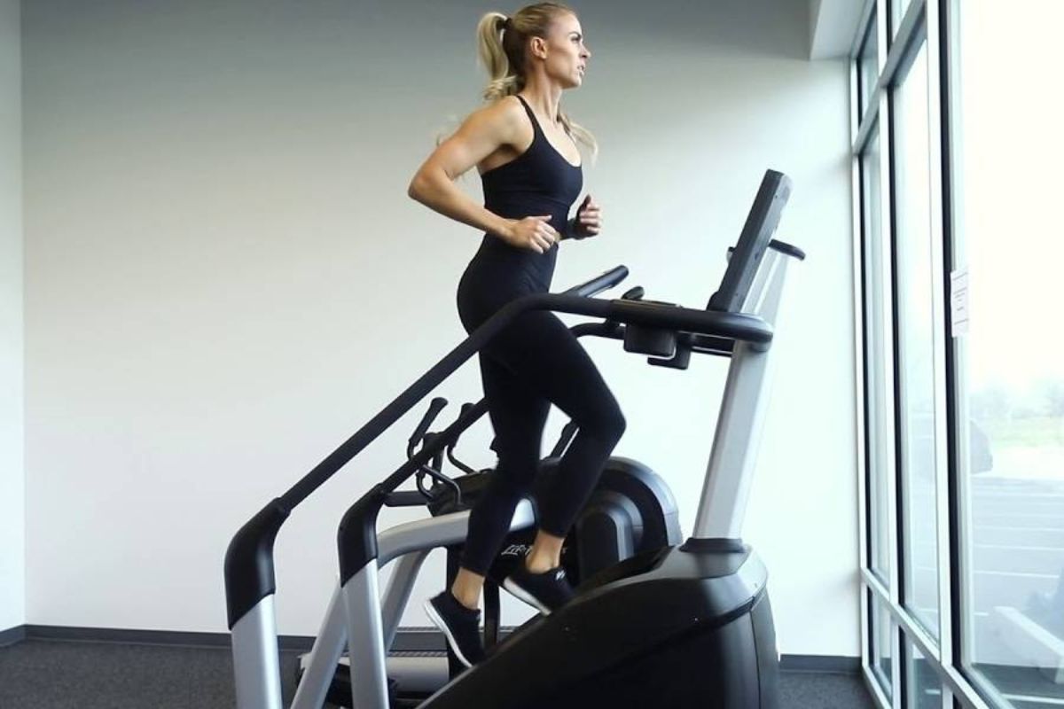 Female athlete training on stairmaster machine in gym