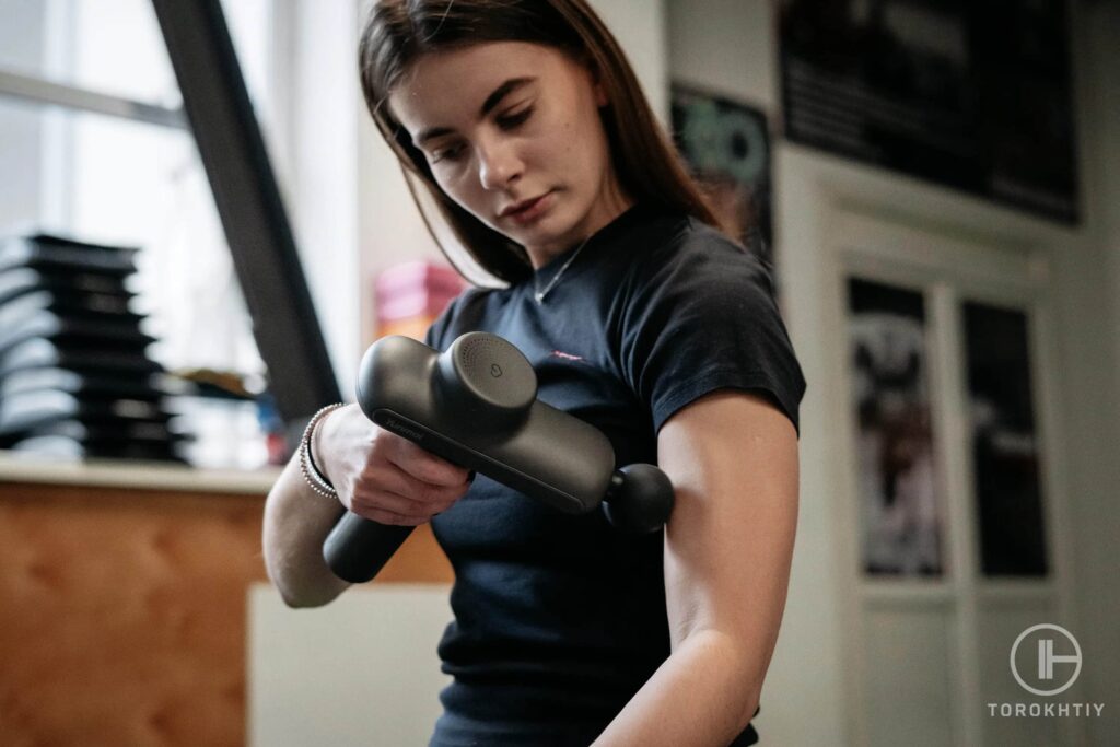 woman uses massage gun