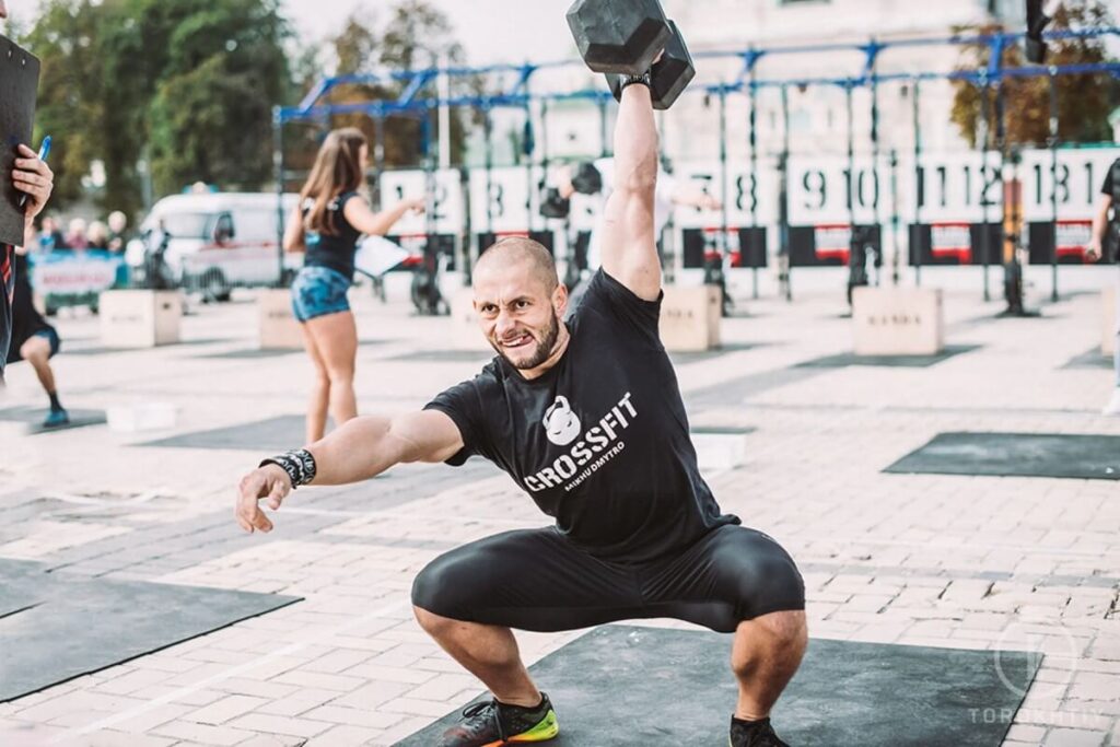 athlete training with dumbbell outside