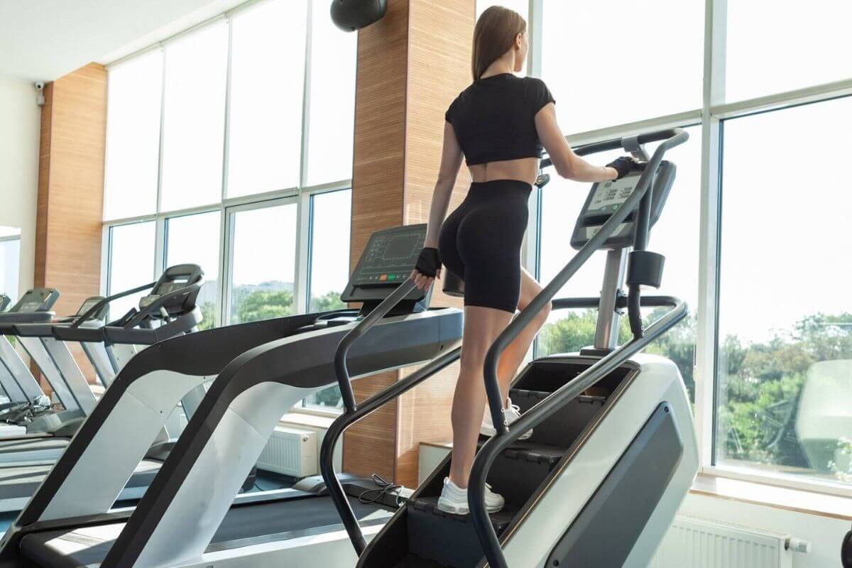 Female athlete training on stairmaster in front of a window