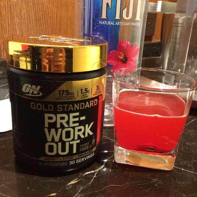 optimum preworkout bottle and glass of supplement shake