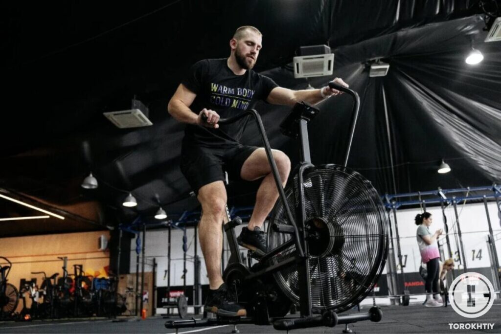 athlete exercising on echo bike in gym