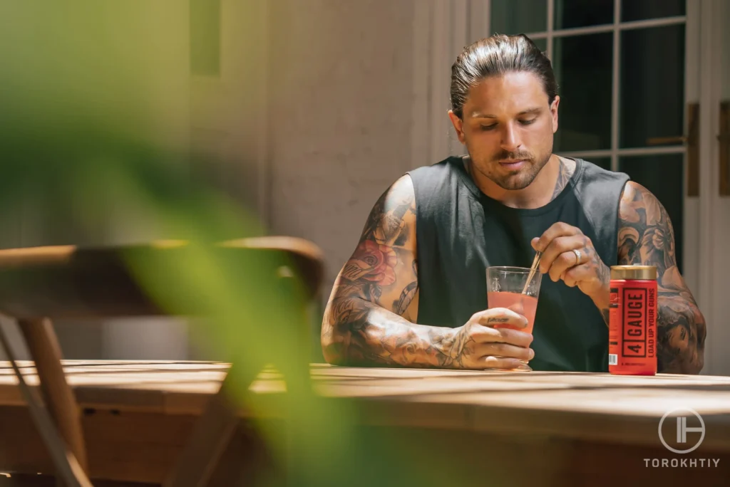 man sits by table and makes protein shake