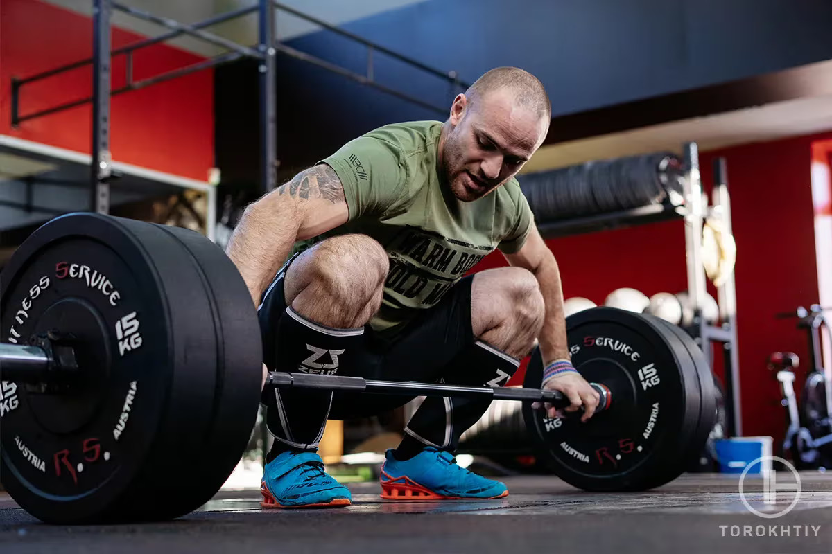 athlete and barbell preparing to workout