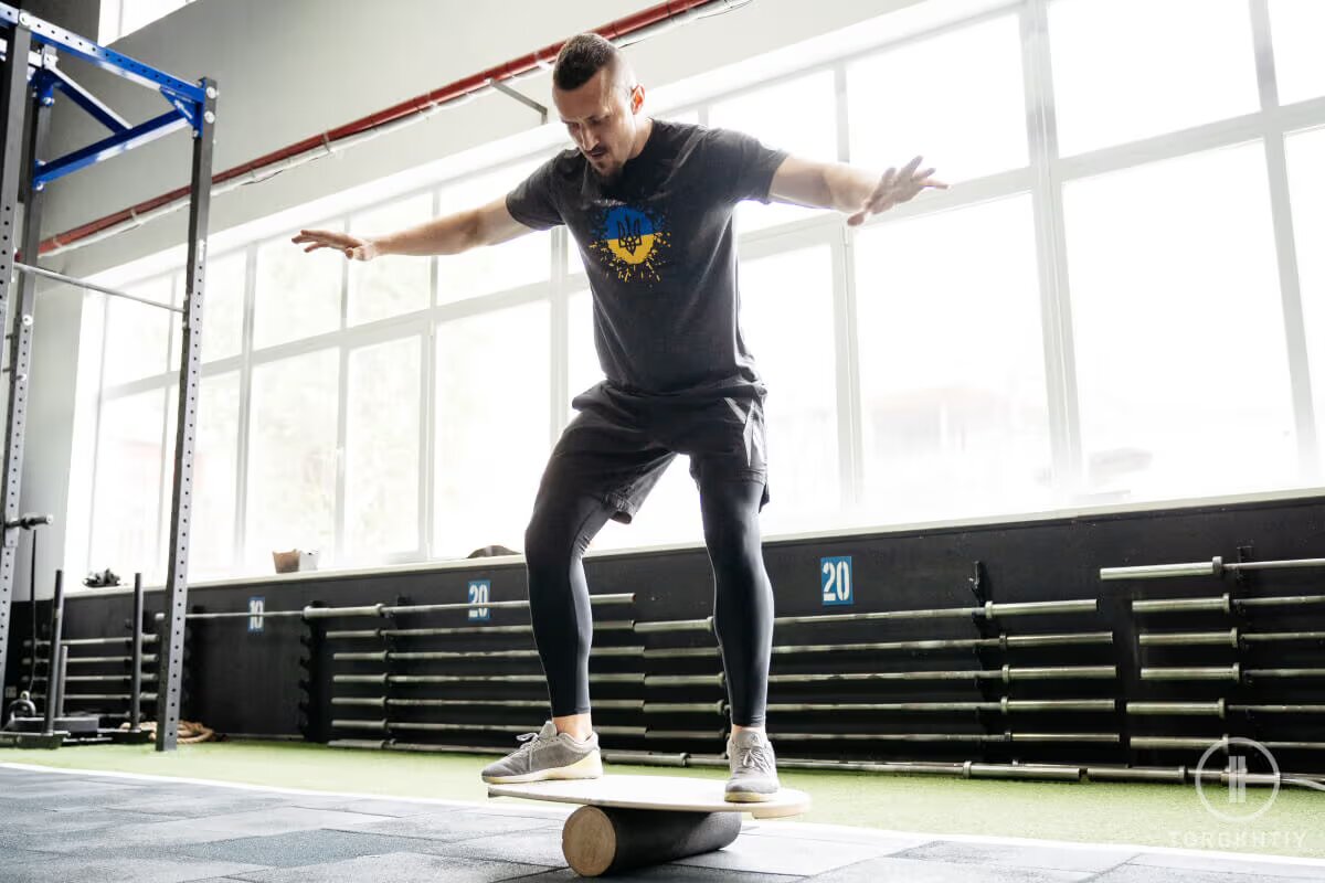 athlete is training on balance board in gym