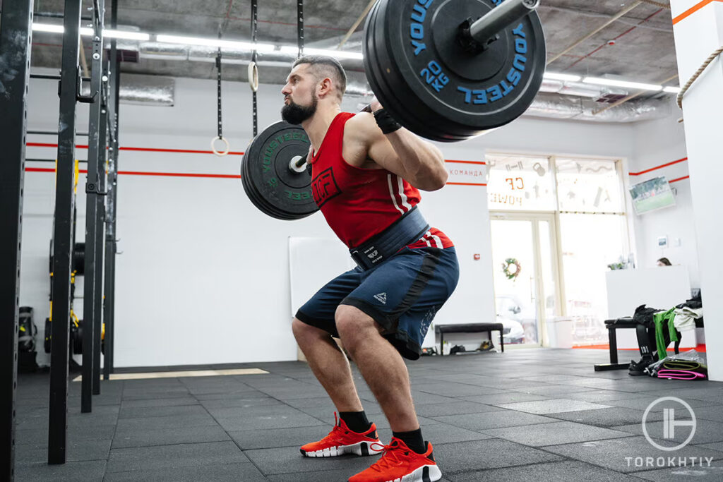 Athlete Squatting in Gym