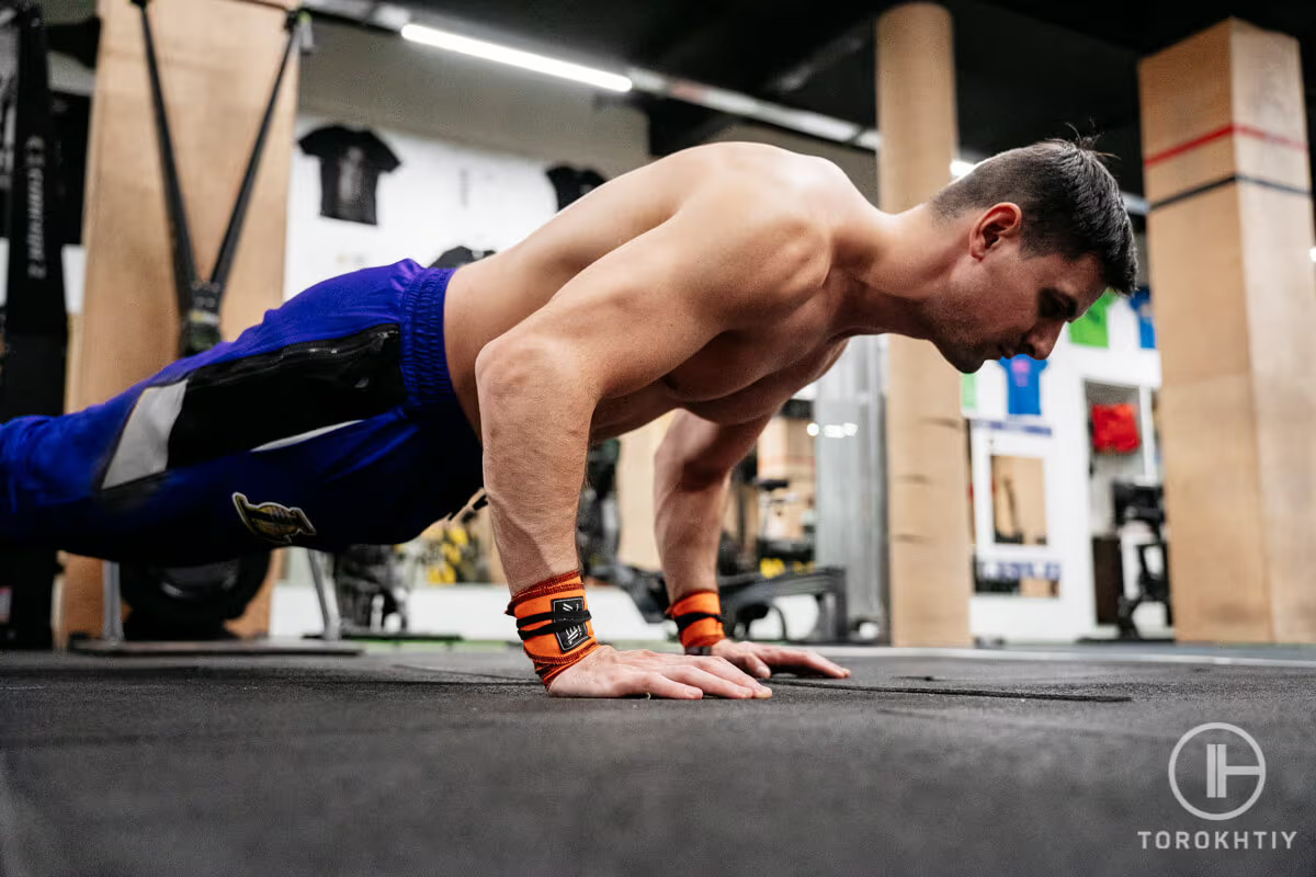 athlete doing push ups in gym