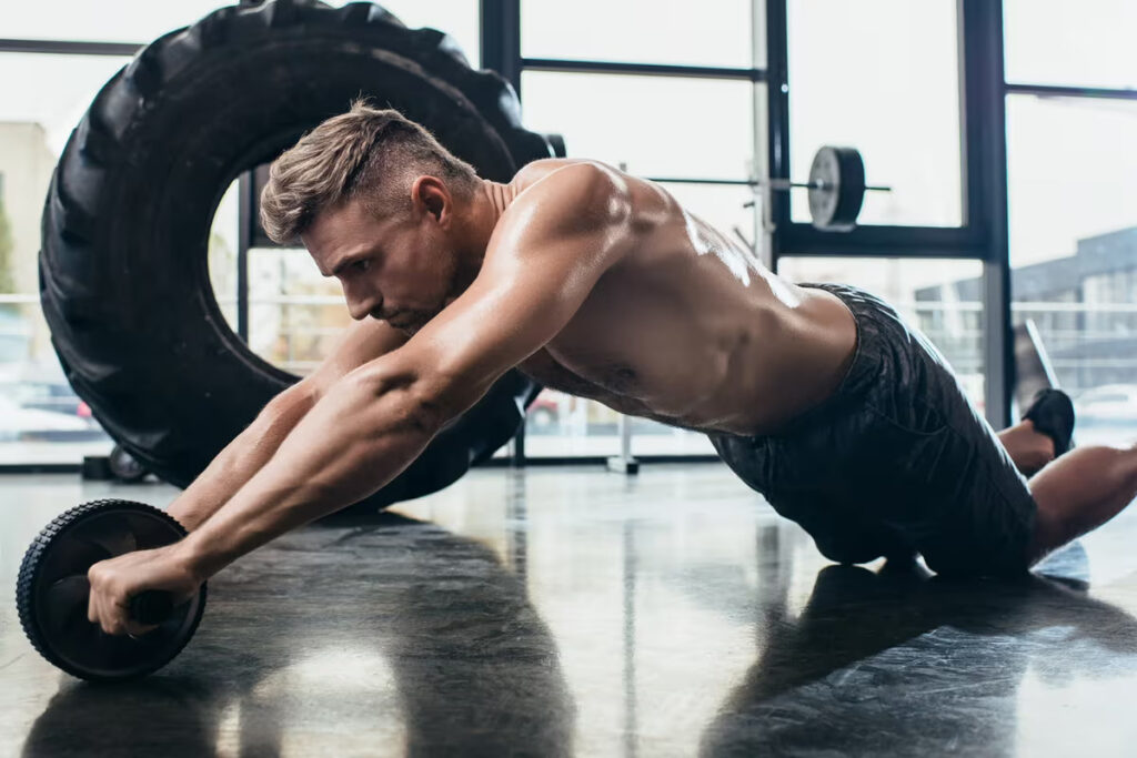 athlete training with ab roller at gym