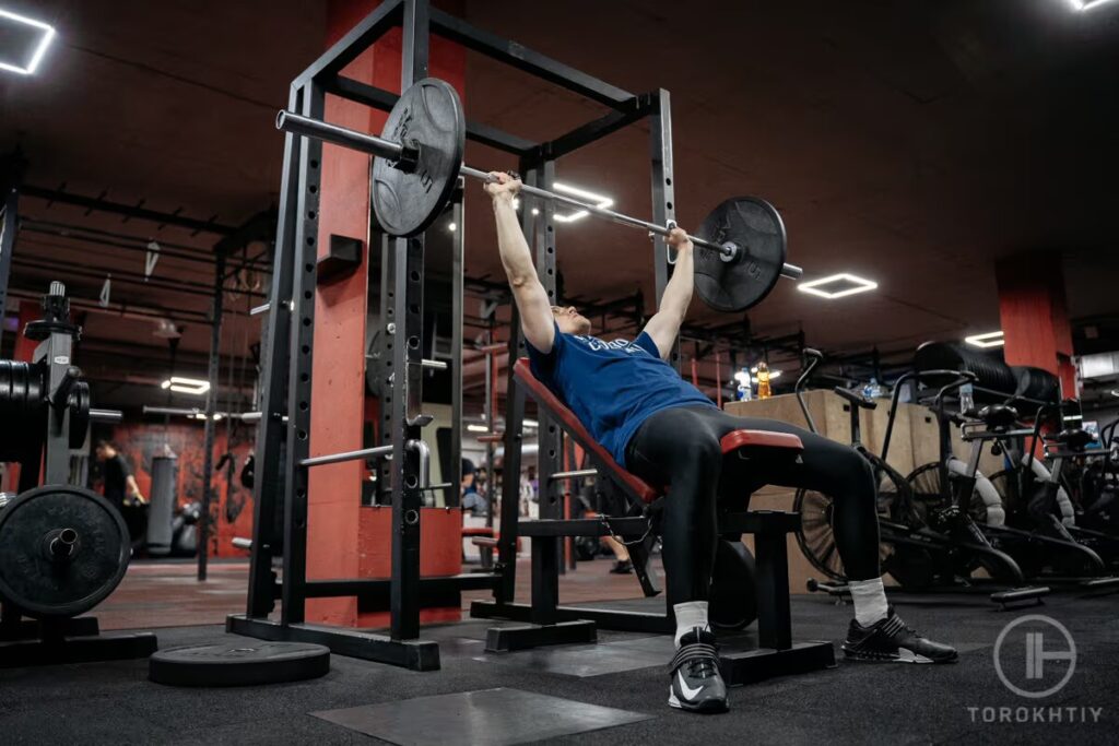 athlete does exercise with barbell in gym