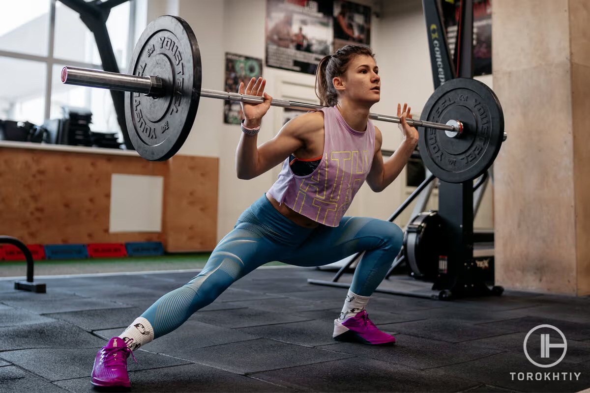 athlete woman doing workout with barbell