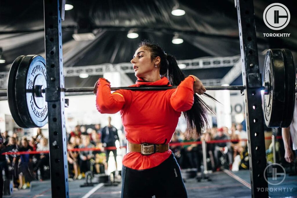 female athlete deadlifting orange costume torokhtiy