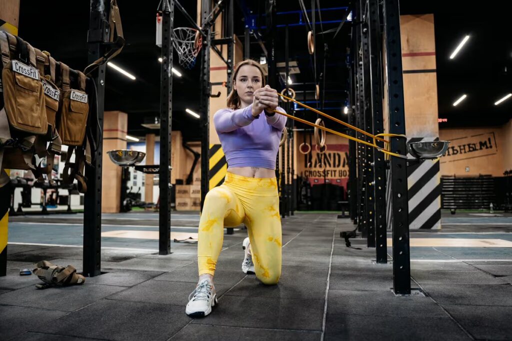 woman exercises in gym with resistance band