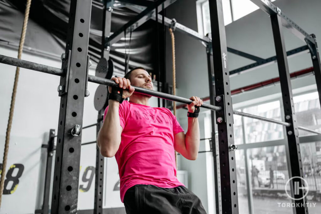 athlete doing pull-ups in gym