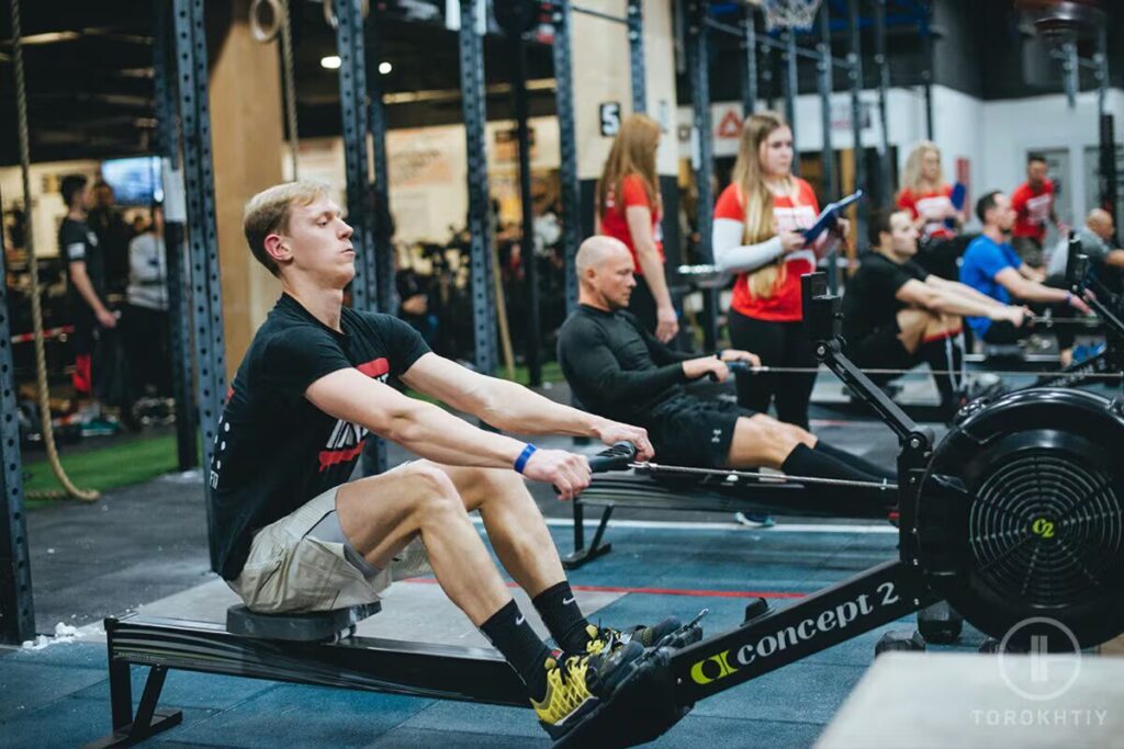 athlete works out on rowing machine in gym