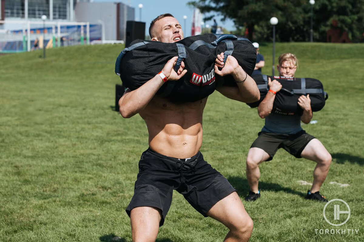 athlete working out with sandbags