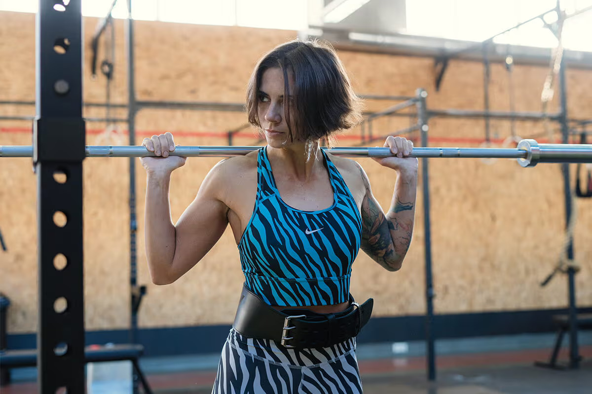 athlete woman wearing weight belt and standing by weightlifting stance