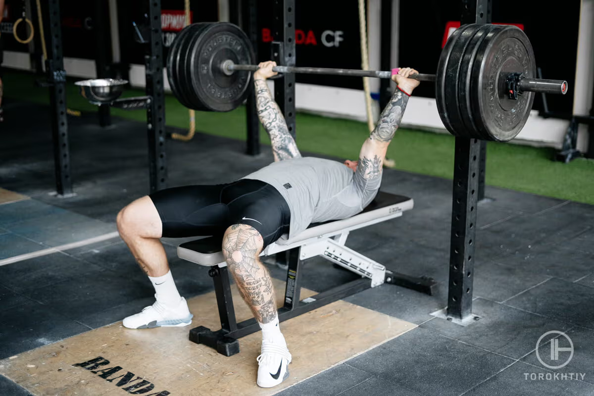 athlete doing workout on weight bench in gym