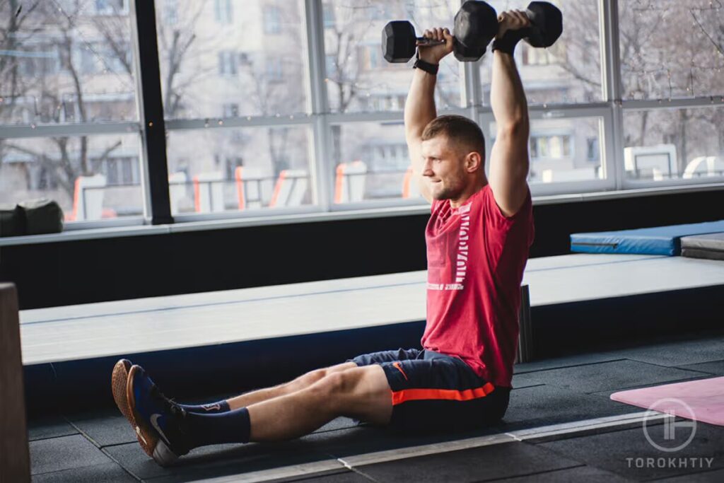 athlete workos out with dumbbells